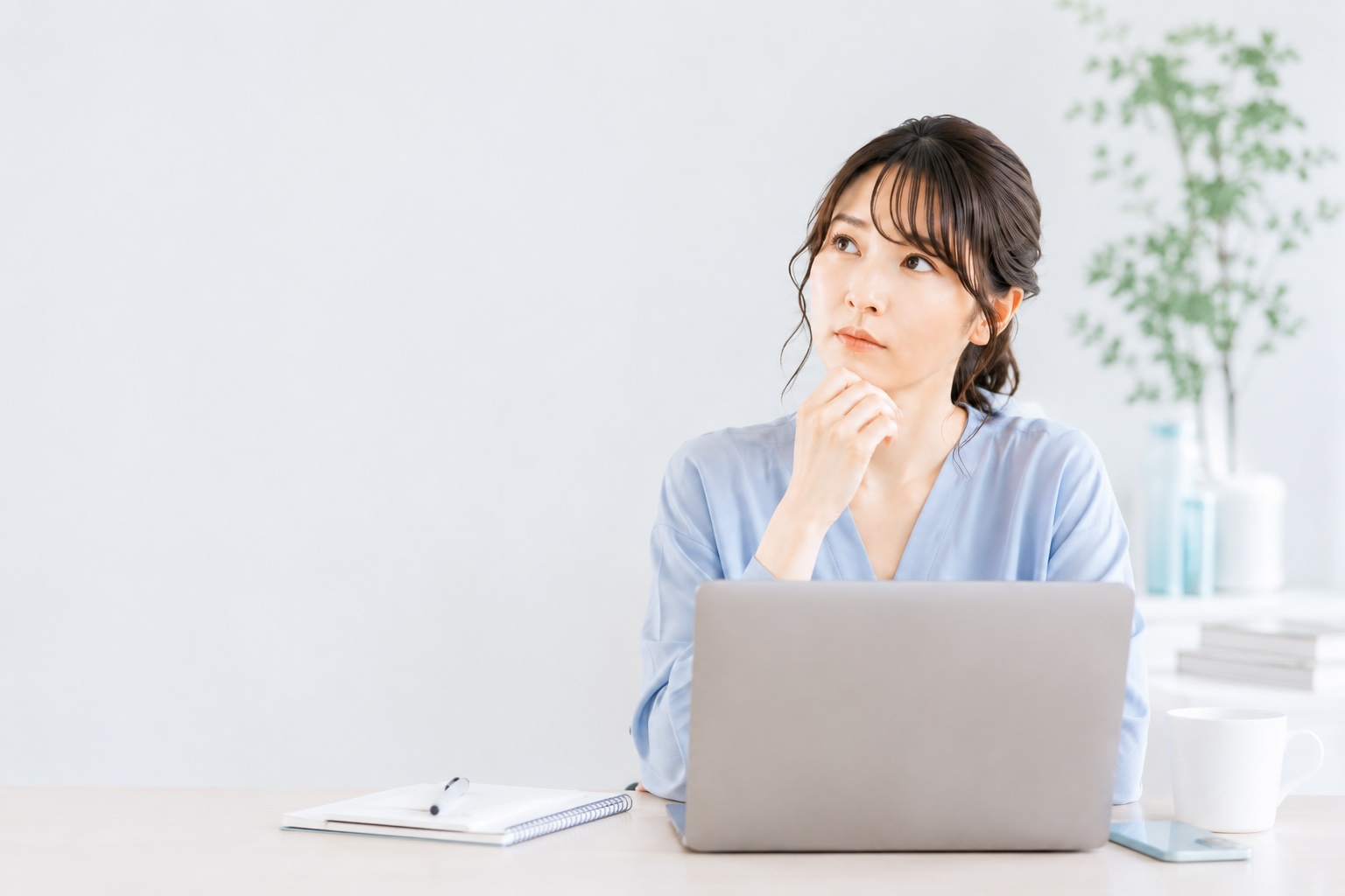 ホームページ制作の方法に悩みながら考えている女性のイメージ