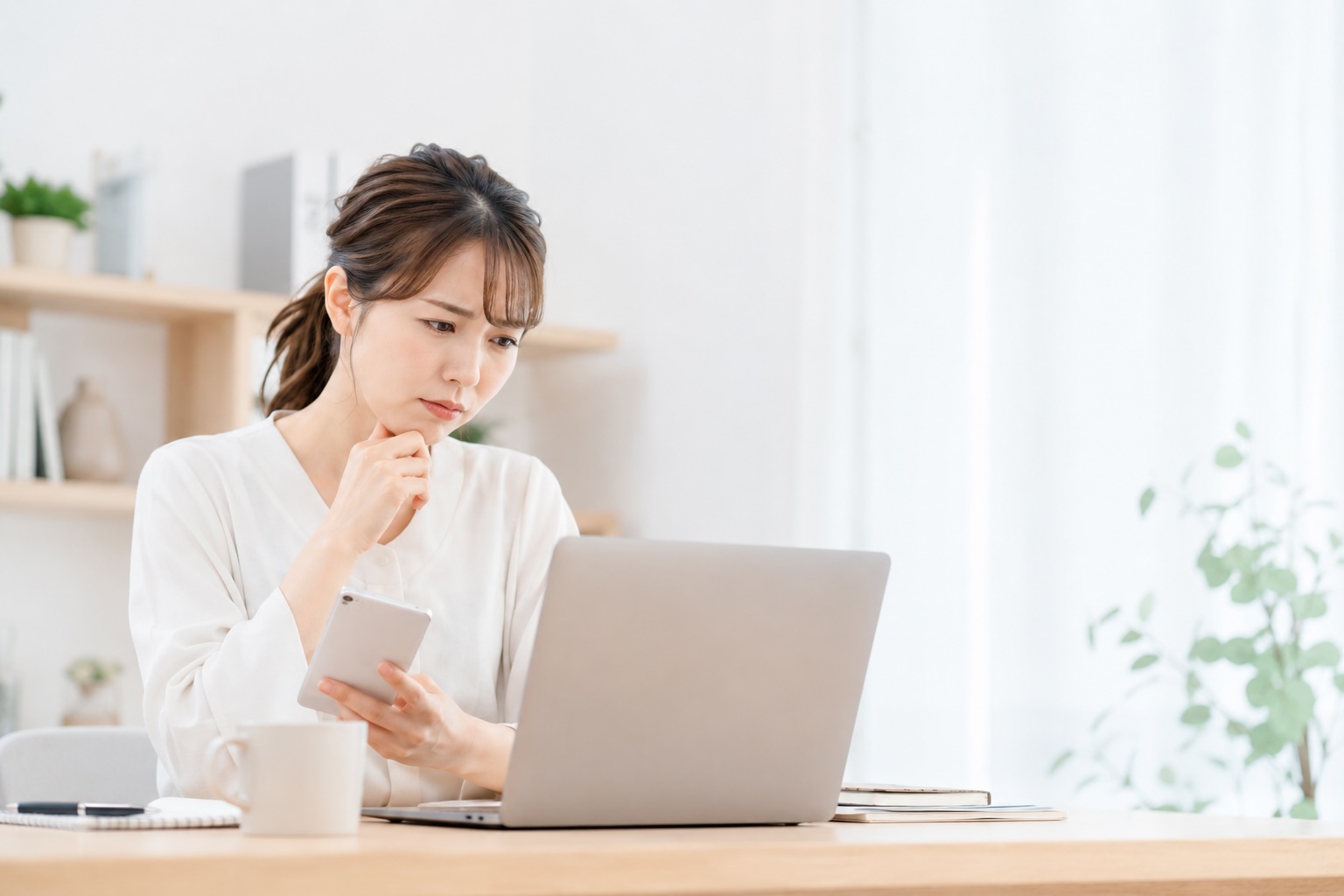 ホームページを見ながらお問い合わせが増えない原因を考えている女性のイメージ