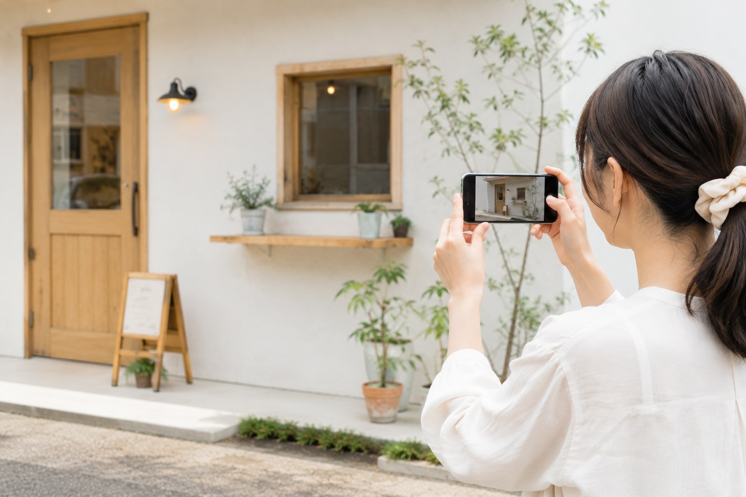 明るい時間帯にスマートフォンで撮影している女性のイメージ